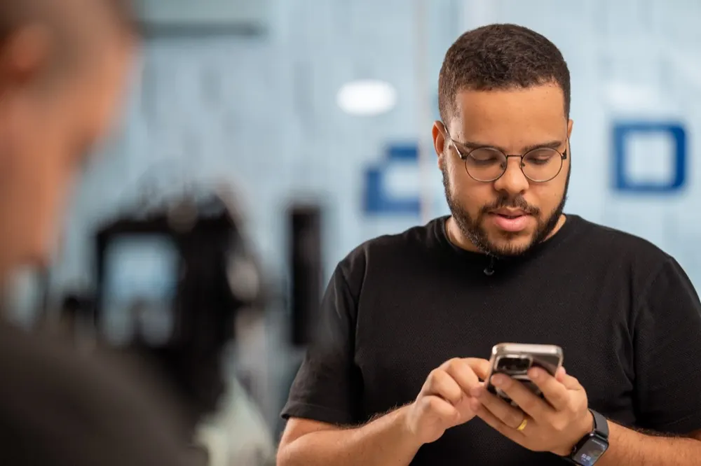 Profissional da Dyna Tecnologia testando um atendimento via WhatsApp no celular